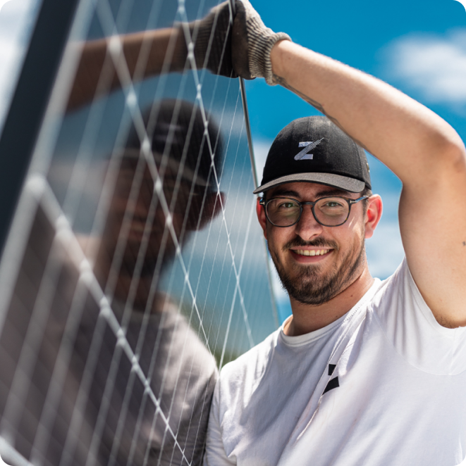 Technicien Zest portant un panneau solaire