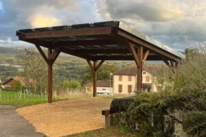 Carport en bois équipé de panneaux solaires dans un environnement rural