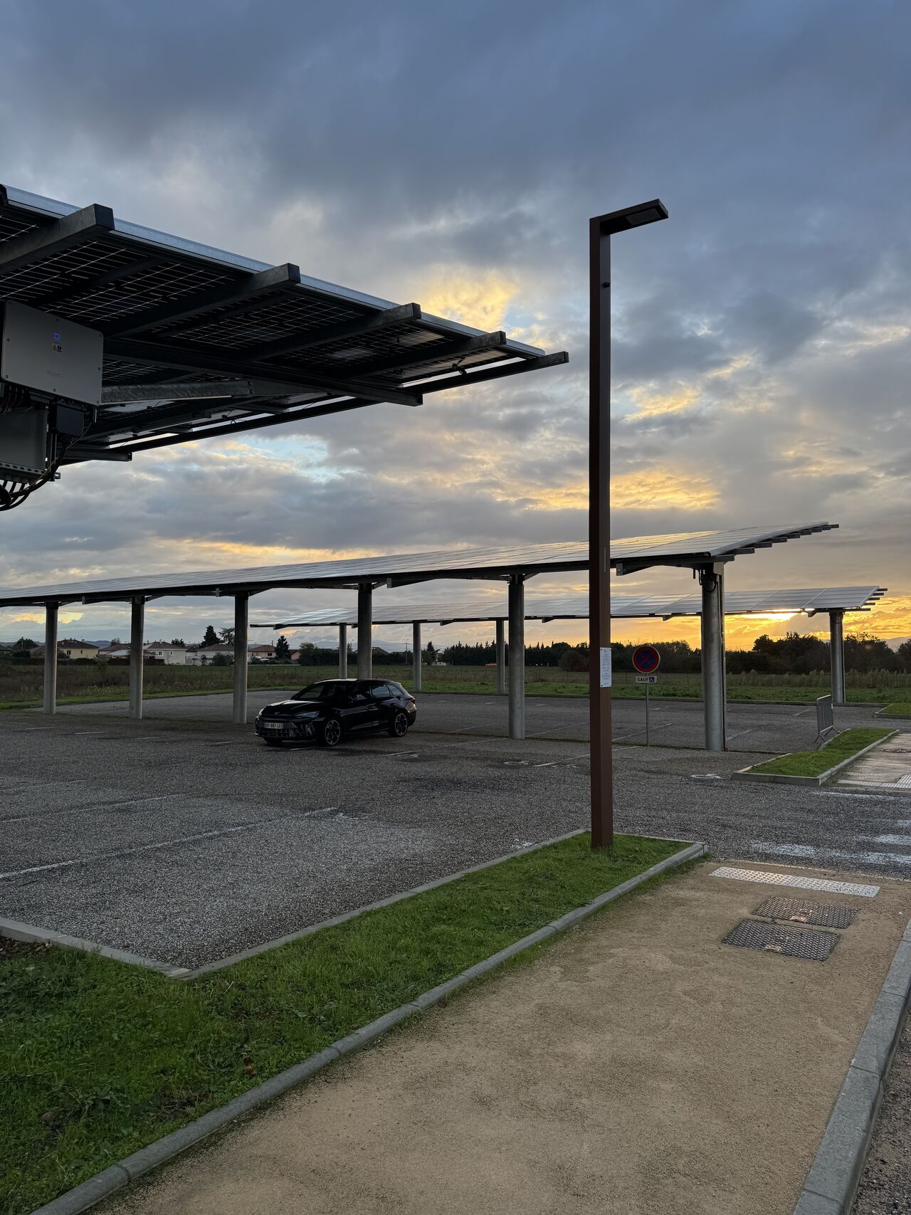 Ombrières photovoltaïques sur parking avec voiture garée dessous