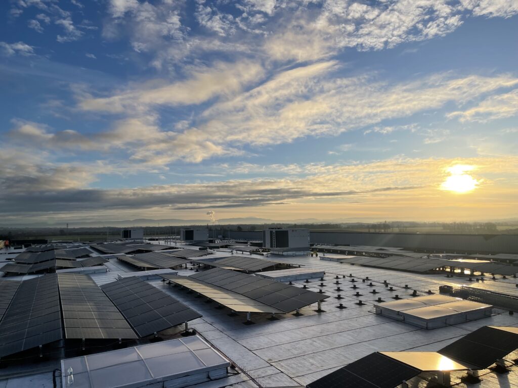 Installation photovoltaïque industrielle sur grande toiture-terrasse au coucher du soleil