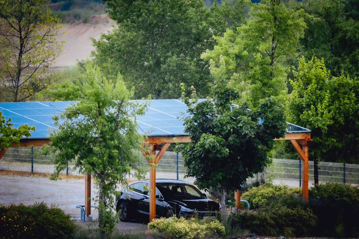 Carport solaire en bois avec voiture garée dessous