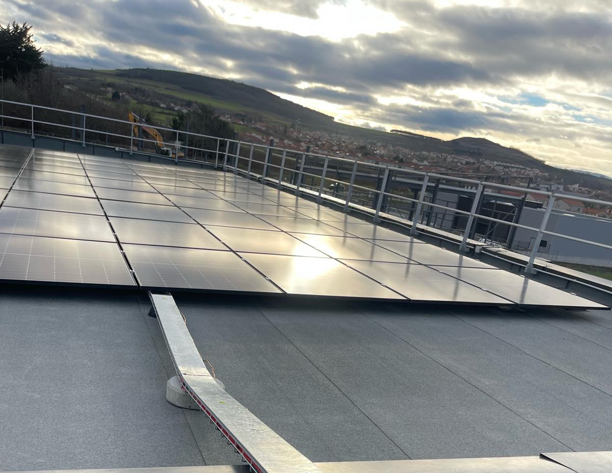 Panneaux solaires sur toiture-terrasse avec vue sur paysage vallonné