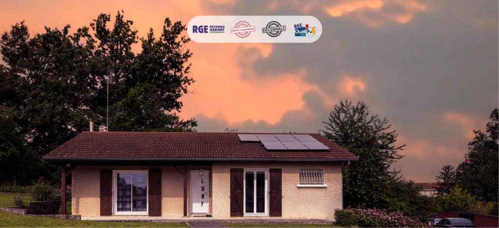 Maison avec panneaux solaires sur toit de tuiles rouges au coucher du soleil, logos RGE et certifications visibles