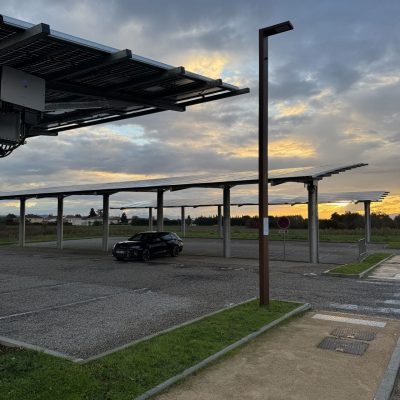 Ombrières photovoltaïques sur parking avec voiture garée dessous