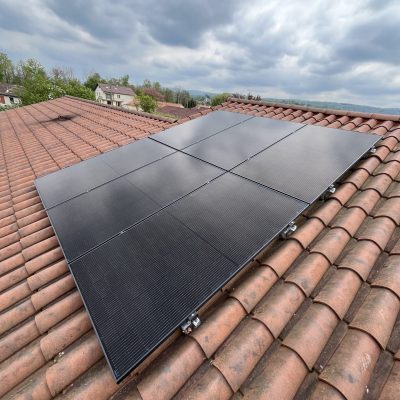 Installation de panneaux solaires sur toit en tuiles canal sous ciel nuageux