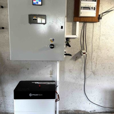 Armoire électrique grise avec écran de contrôle et batterie Pylontech installées dans un garage