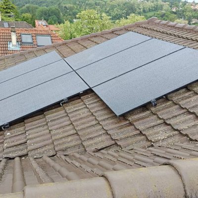 Panneaux solaires installés sur toiture en tuiles avec vue sur quartier résidentiel