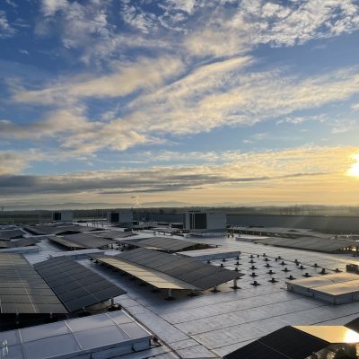 Installation photovoltaïque industrielle sur grande toiture-terrasse au coucher du soleil