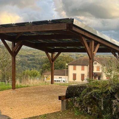 Carport en bois équipé de panneaux solaires dans un environnement rural