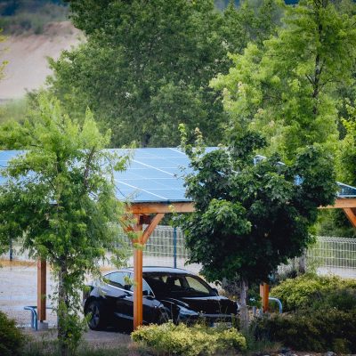 Carport solaire en bois avec voiture garée dessous