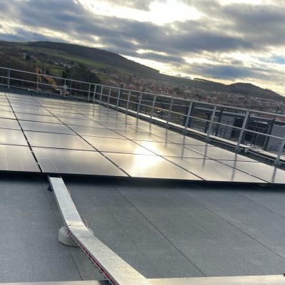 Panneaux solaires sur toiture-terrasse avec vue sur paysage vallonné