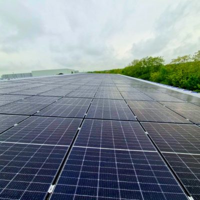 Installation photovoltaïque sur toiture plate avec végétation en arrière-plan